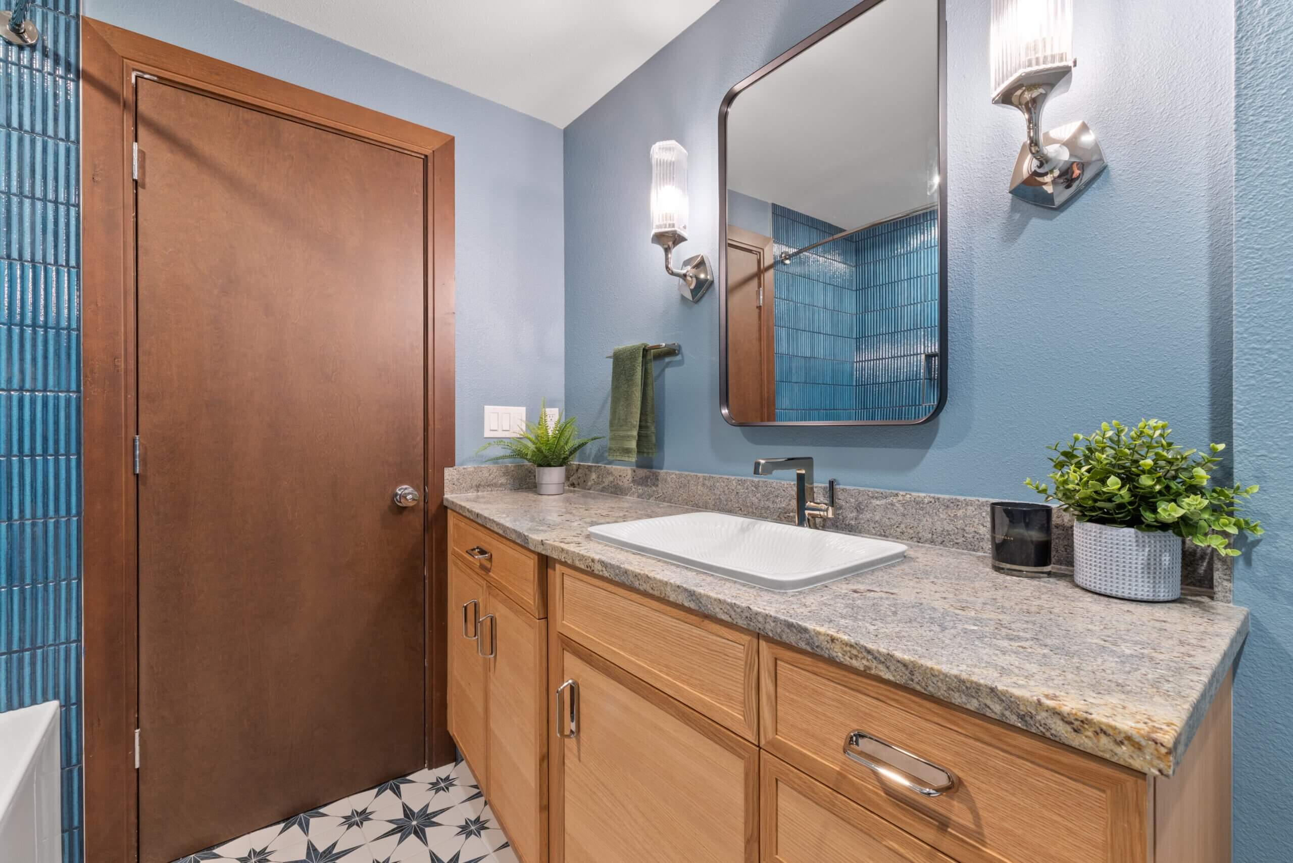 mid century modern bathroom, remodeled bathroom, blue tile shower, blue walls, tile flooring